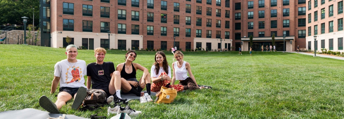 Students sitting on the east campus residence hall quad