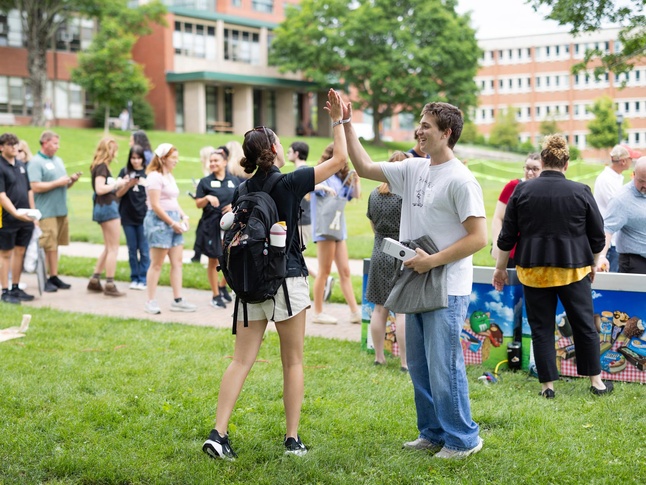 Student high five with orientation guide
